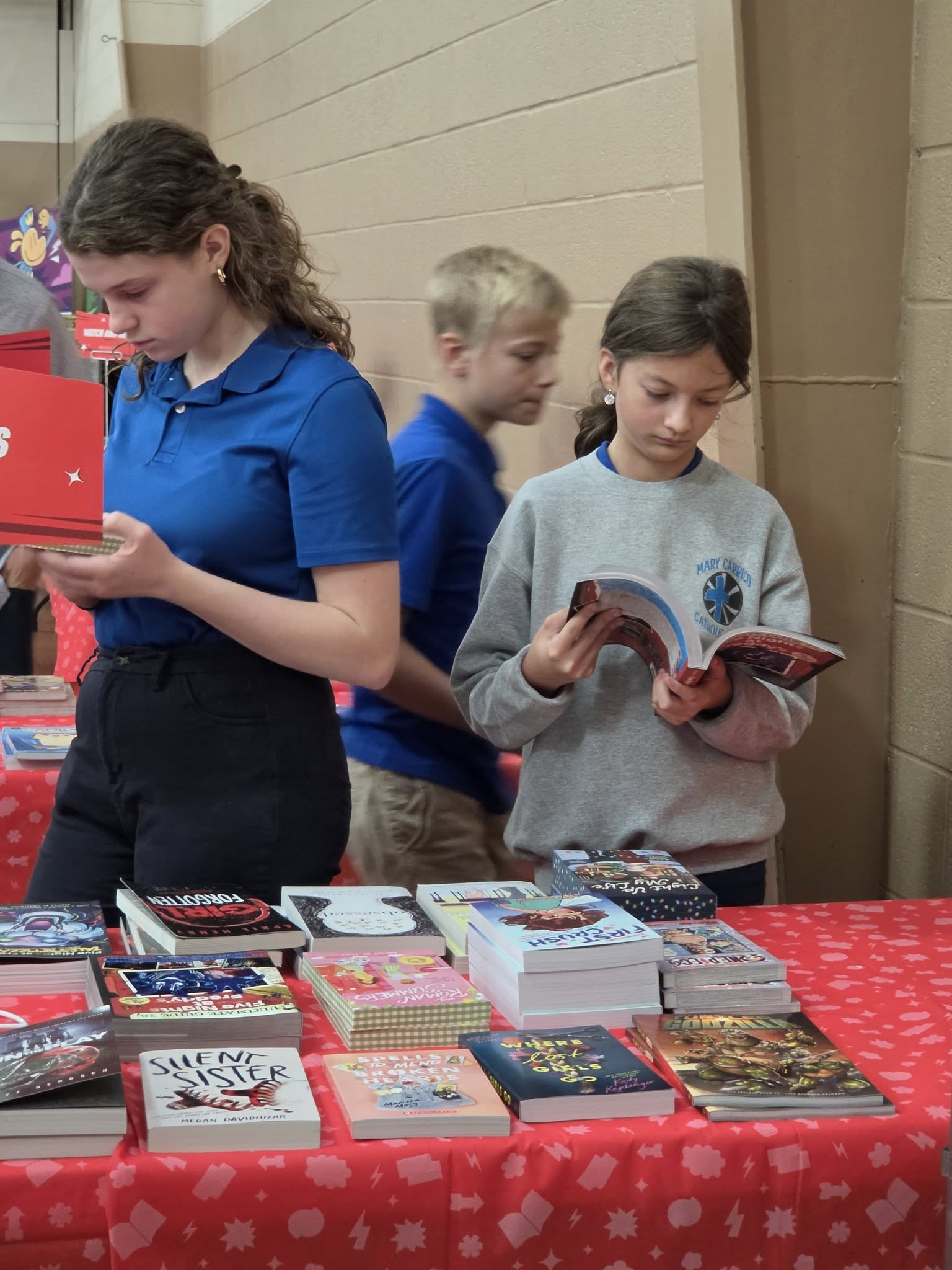 Middle school students look through books at a school book display.